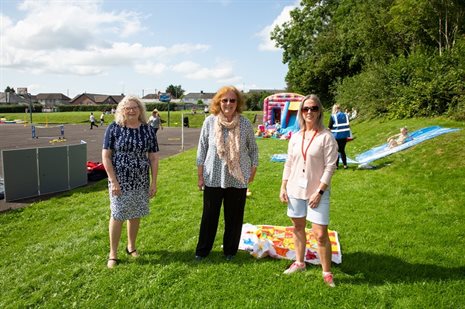 Three ladies in a field with a Bouncy Castle