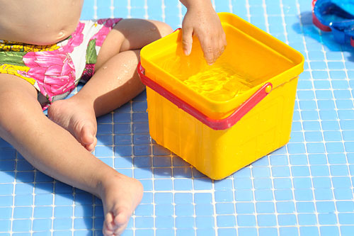 baby playing with a bucket